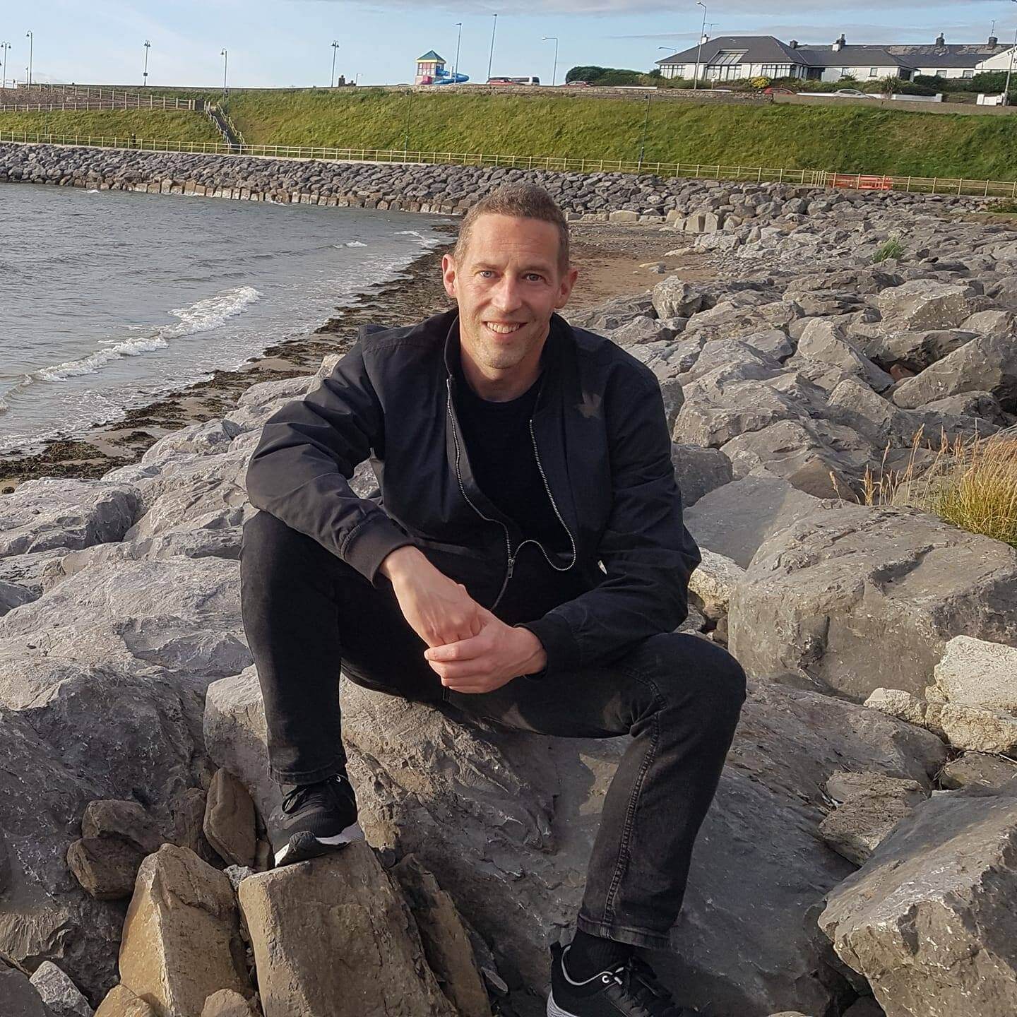 Picture of Padraig Deignan sitting on rocky beach